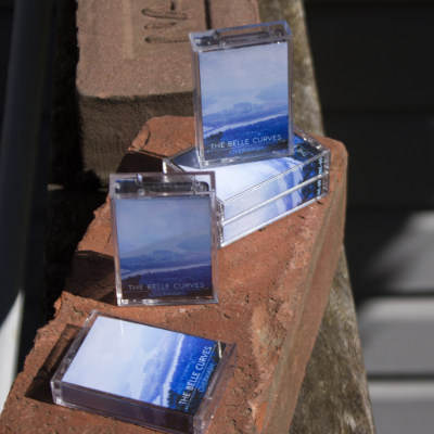 a collection of microcassettes placed on top of a brick for scale :)