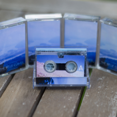 side A of a microcassette, front and center, surrounded by several copies of the same microcassettes