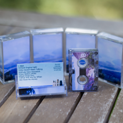 side B of a microcassette and the inside of the j-card, surrounded by copies of the same microcassette